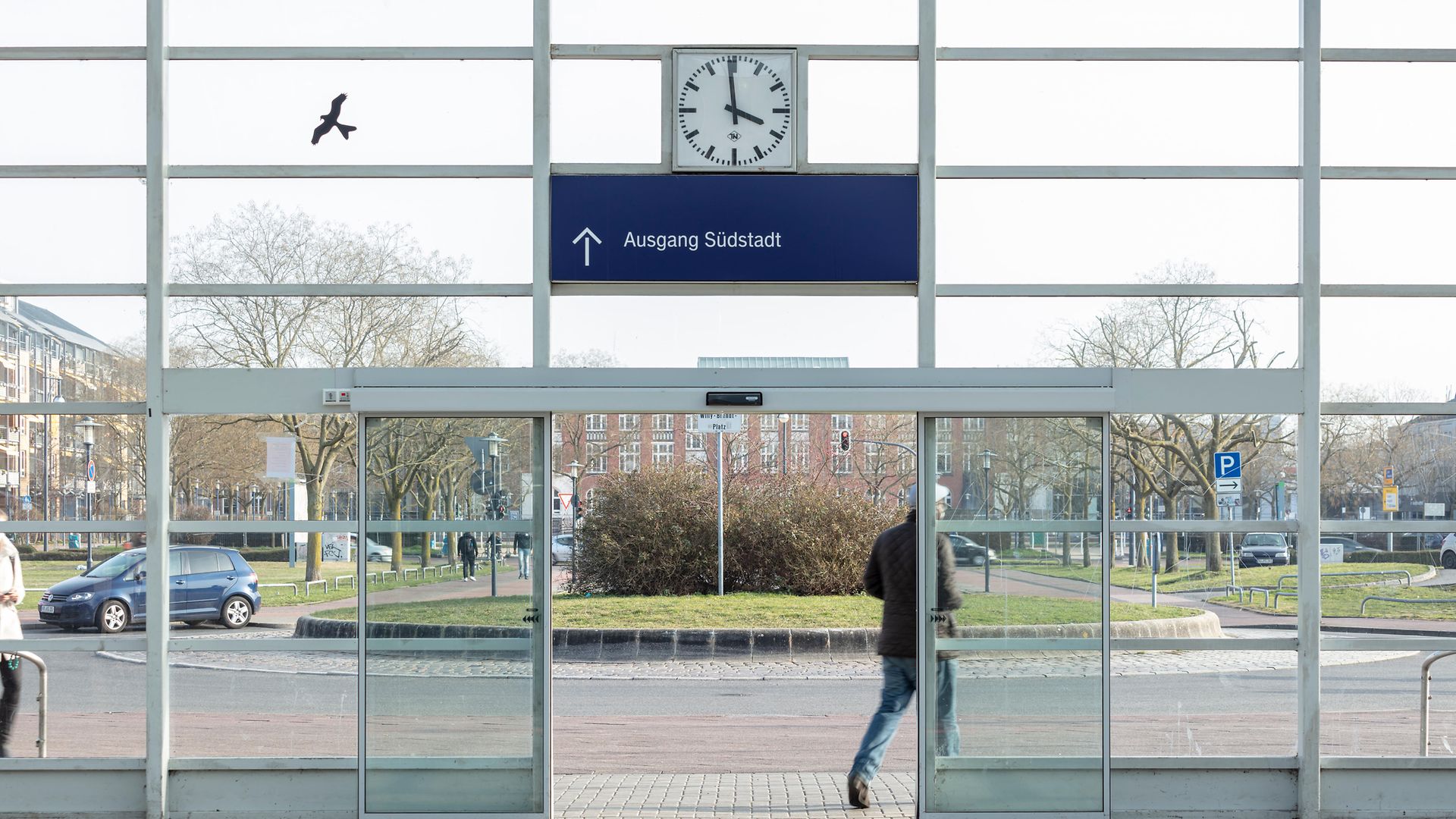 Ein Reisender verlässt das Empfangsgebäude durch die Automatiktür