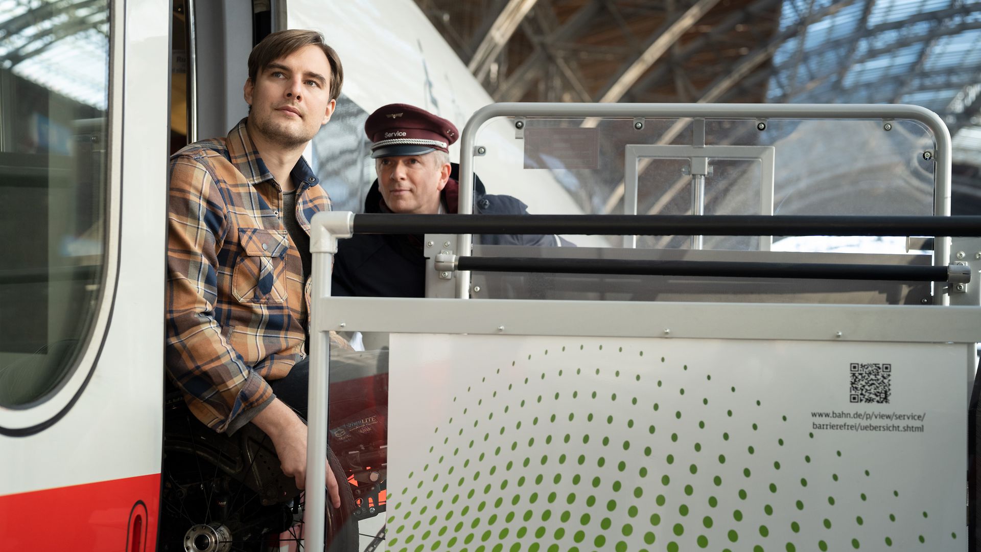Ein Servicemitarbeiter hilft einem Rollstuhlfahrer mit mobilem Hublift beim Ausstieg aus dem ICE