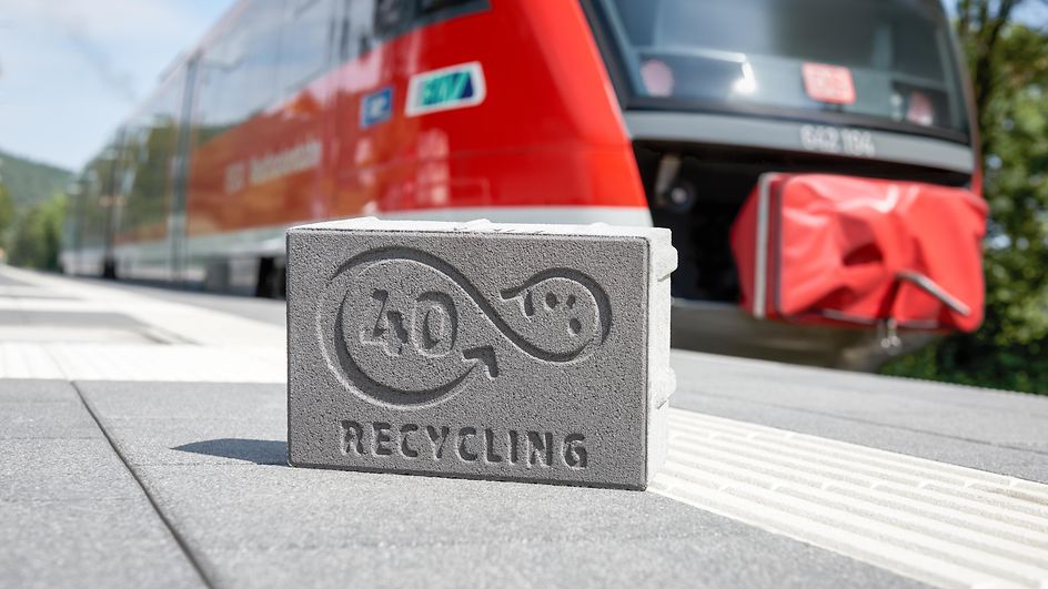 Symbolbild DB RegioNetz Infrastruktur GmbH - Recycling-Stein vor Regionalbahn
