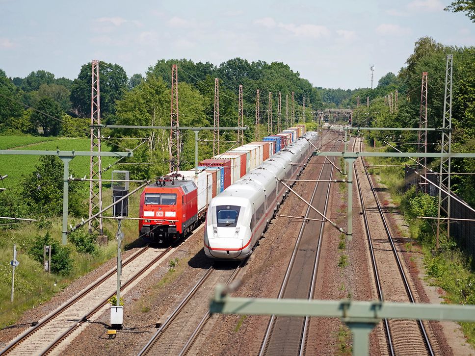 Ein ICE 4 von Hamburg kommend überholt einen Containerzug auf dem Korridor Hannover-Hamburg