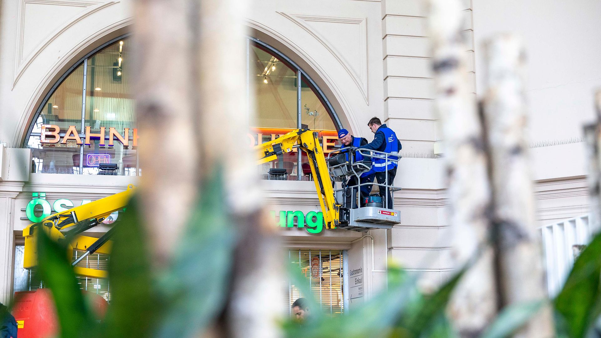 Zwei Männer auf einem Hebekran bei der Reinigung der Glasfassade